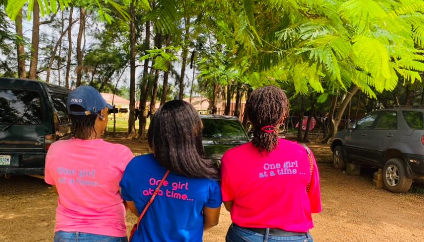 Ladies in blue and pink shirt with their back turned to the camera