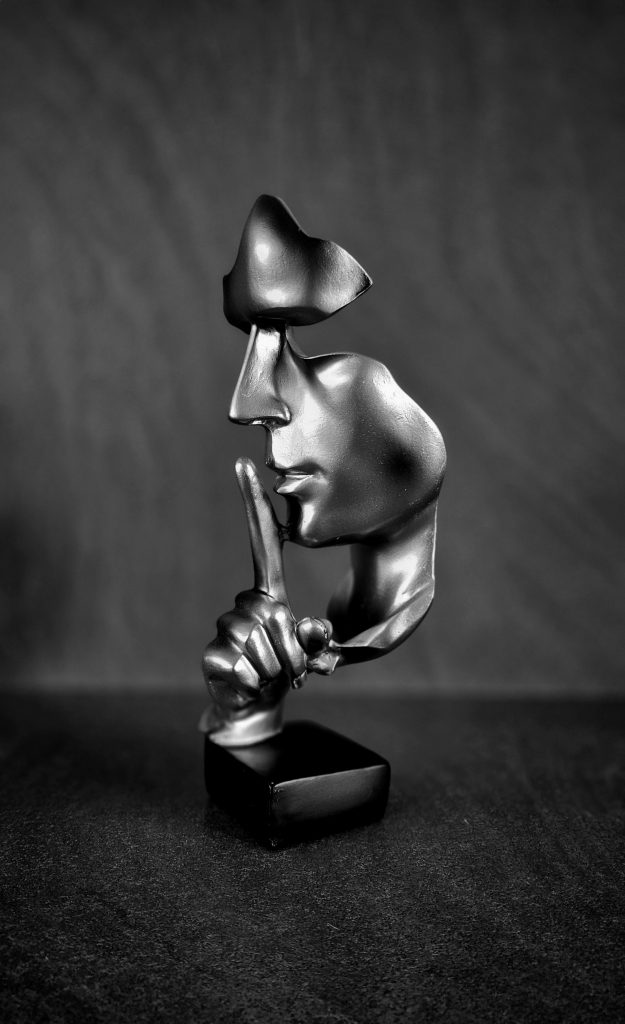 Black abstract sculpture with silencing gesture in monochrome, expressing modern art minimalism.