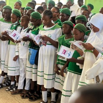 group of children in school holding a book