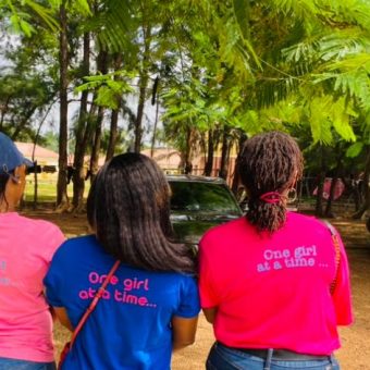 Ladies in blue and pink shirt with their back turned to the camera